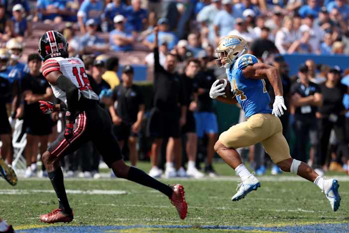 UCLA Bruins running back Zach Charbonnet (24) runs with a ball against Utah Utes cornerback Zemaiah Vaughn (16) during the second quarter at Rose Bowl.